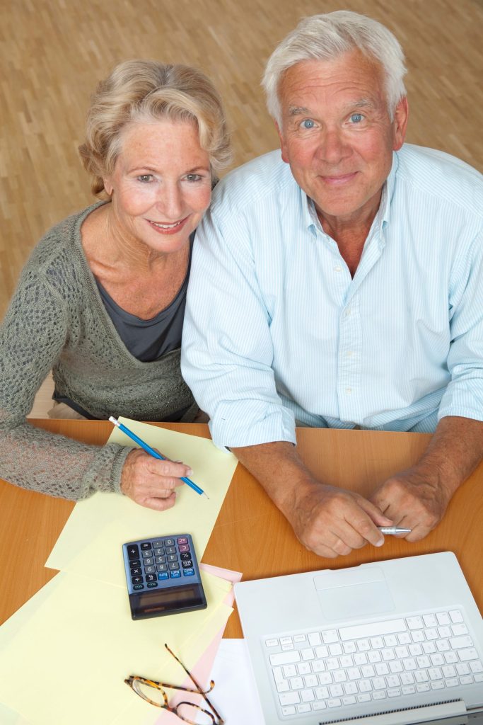 Five Smart Financial Moves to Consider in Your 60s Senior couple using a laptop and calculator for financial planning at home